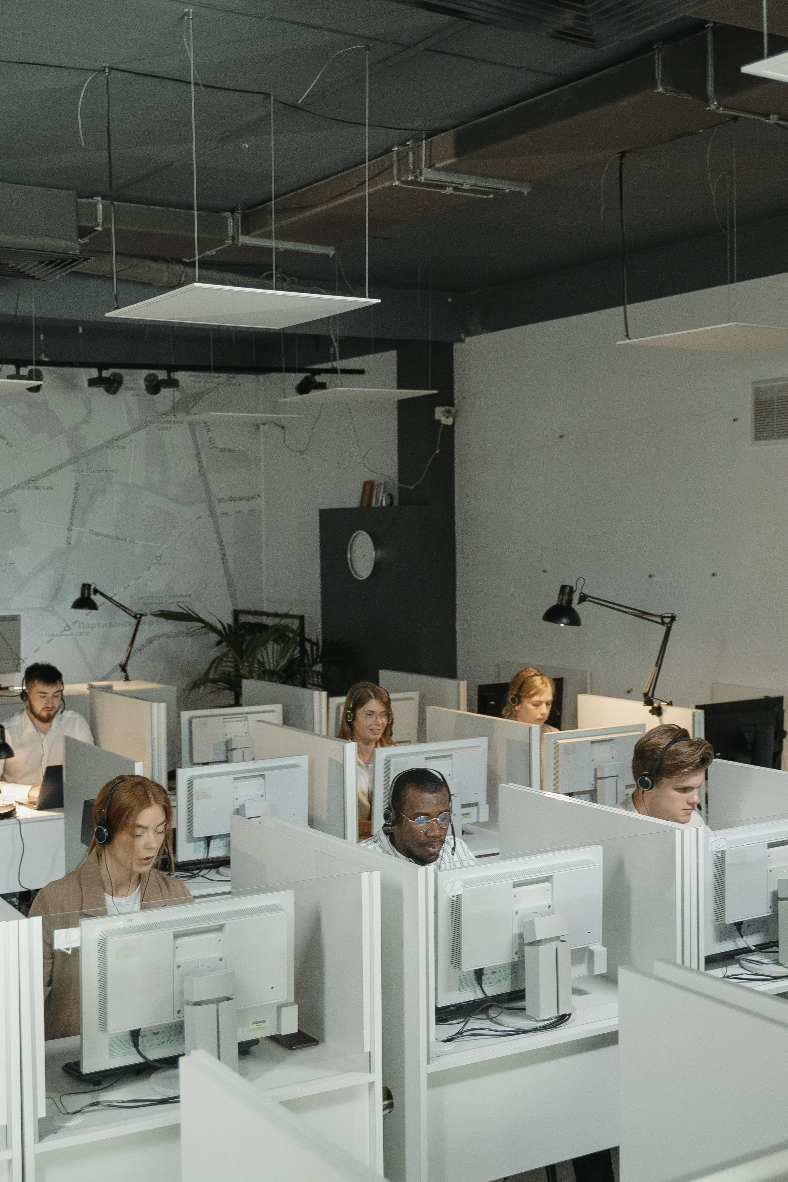 Et supportteam arbeider bak lyse dataskjermer i et åpent kontor